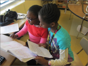 Writer, Emmah and Production Manager, Angel work on the script.